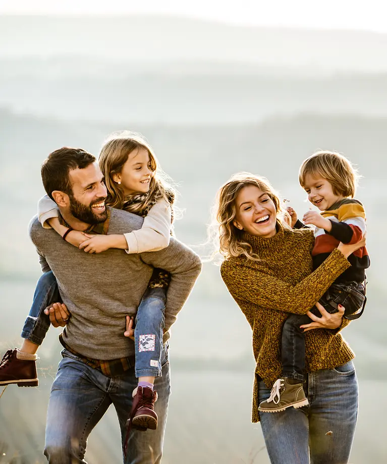 Familie im Herbst - Homepage Paar mit Kindern auf dem Rücken beim Spaziergang