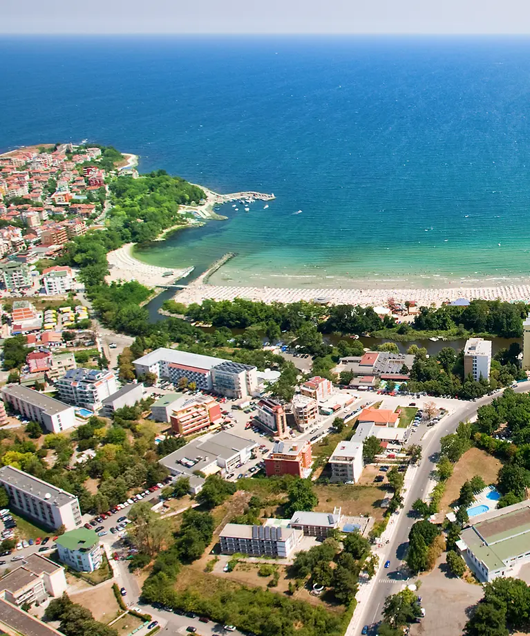 Man sieht verschiedene Häuser, die in der Nähe von einem Strand liegen.