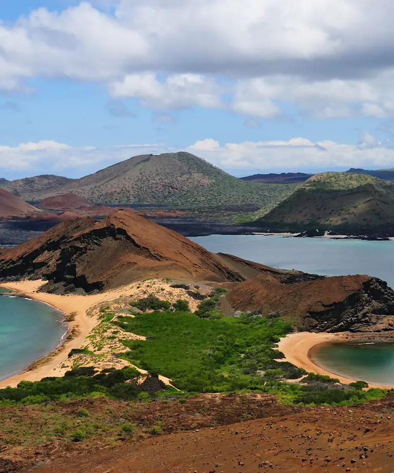 Man erkennt die Galapagosinseln. Im Hintergrund sind Berge zu sehen. Links und rechts ist Wasser.