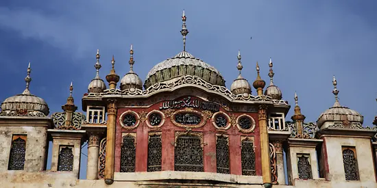 Man sieht eine alte Moschee, die mit vielen kleinen Details verziert ist.