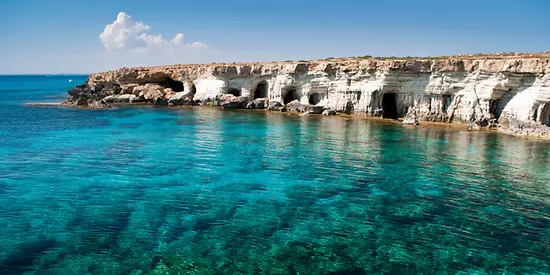 Man erkennt eine Bucht mit kristallklarem türkisen Wasser. 