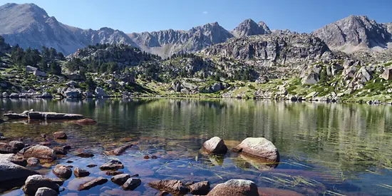 Man sieht mehrere Berge an einem See.