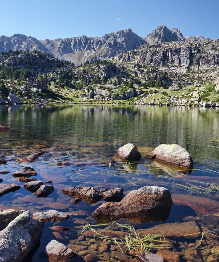 Man sieht mehrere Berge an einem See.