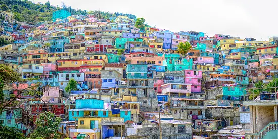 Man sieht die Hauptstadt Port-au-Prince mit vielen bunten Häuser entlang eines Hügels.