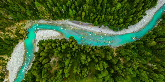 Man sieht einen türkisfarbenen Flusslauf.