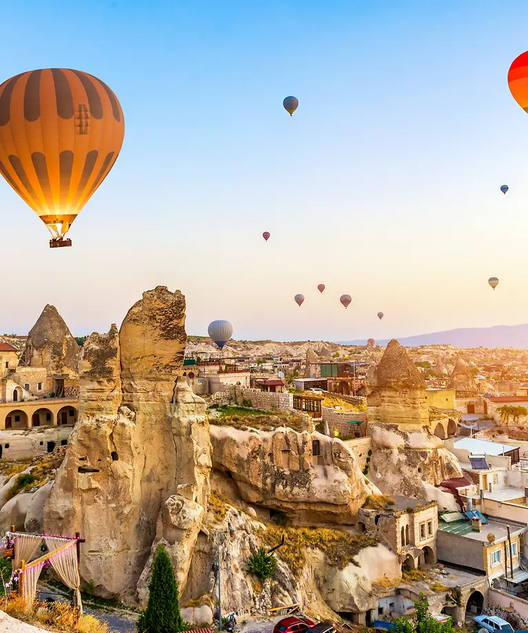 Zu erkennen sind viele Heißluftballons und Felsen.