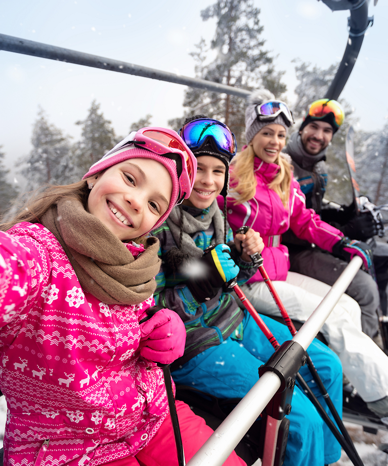 Eine Familie sitzt in einem Skilift und machen ein Selfie. 